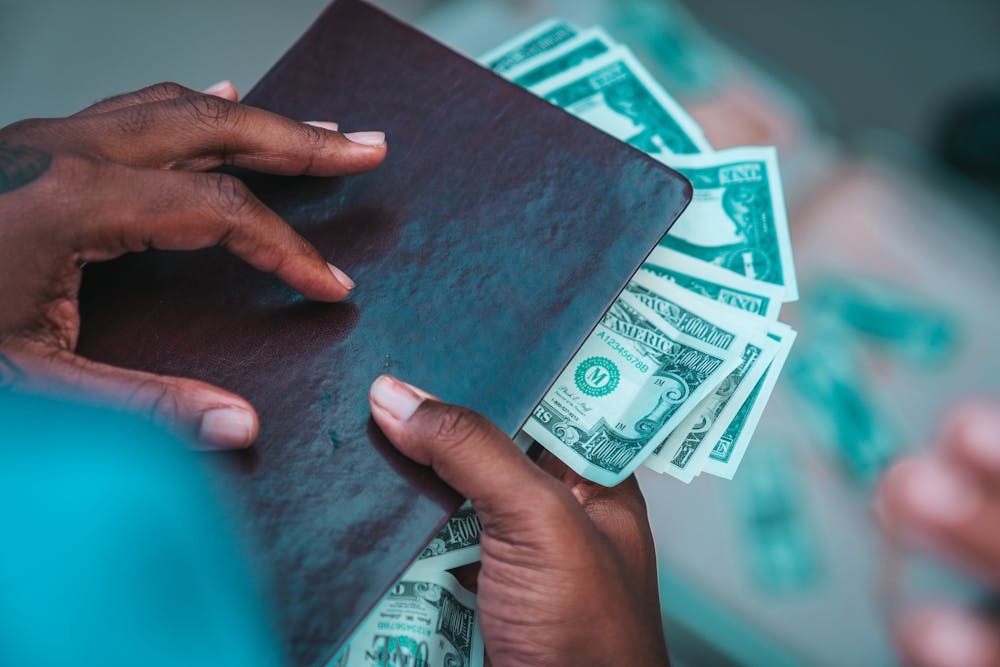 Money hacks - Man hands holding file with cash.